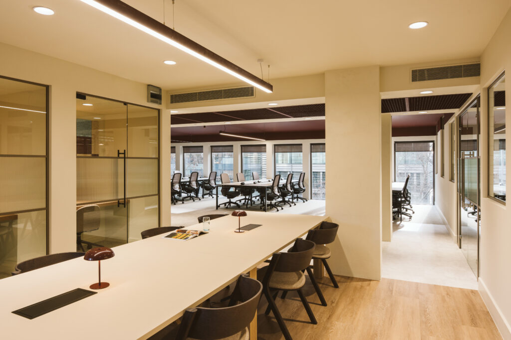 Boardroom-style meeting area at Cannon Green with a long table, chairs and street-facing windows