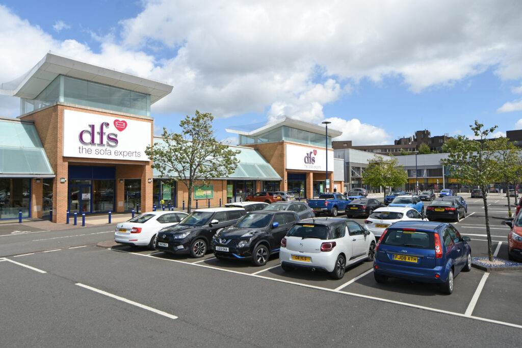 DFS sofa store frontage and car park at Abbotsinch Shopping Park with retail units beyond