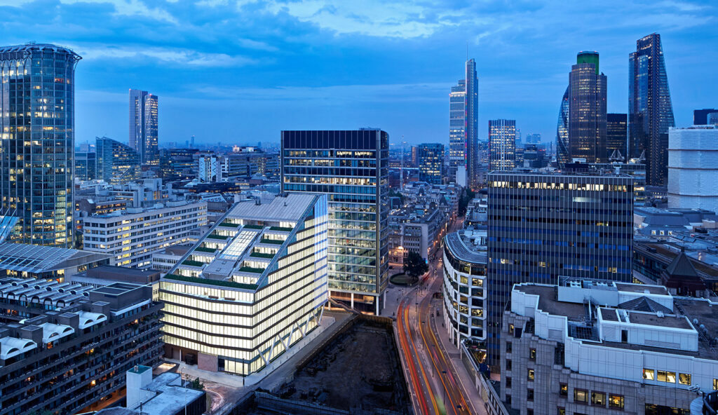 Dusk view of Moor Place's raking concrete columns beneath its gold fin-covered curtain wall