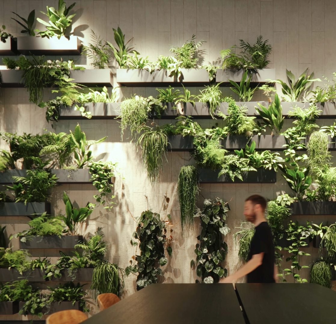 Living wall of trailing plants inside a building, with a table and a person walking past in the foreground