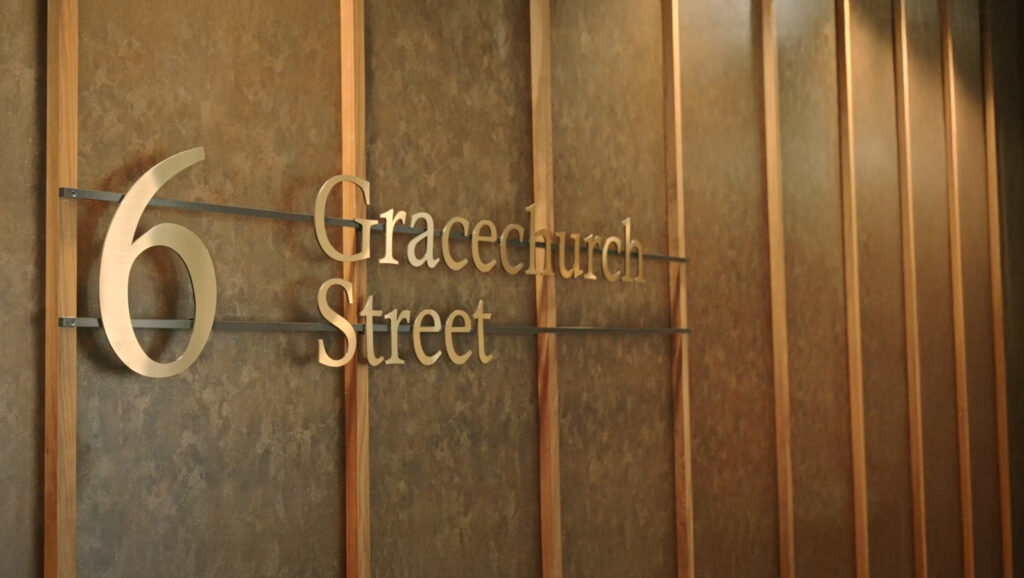 Brass "6 Gracechurch Street" lettering on the timber-panelled reception wall