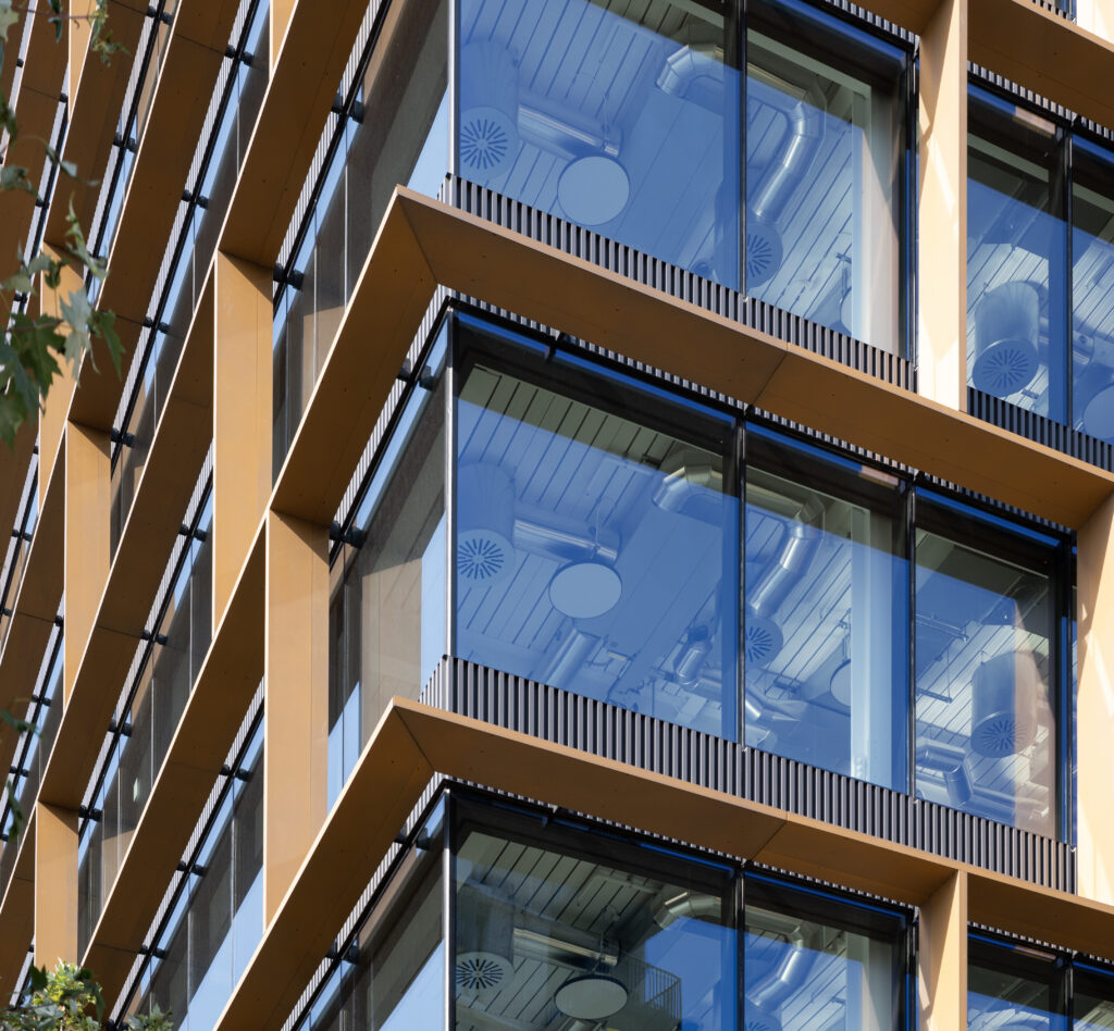 Close-up of Osmo Nine Elms' bronze-clad balconies, with exposed services visible through the glazing